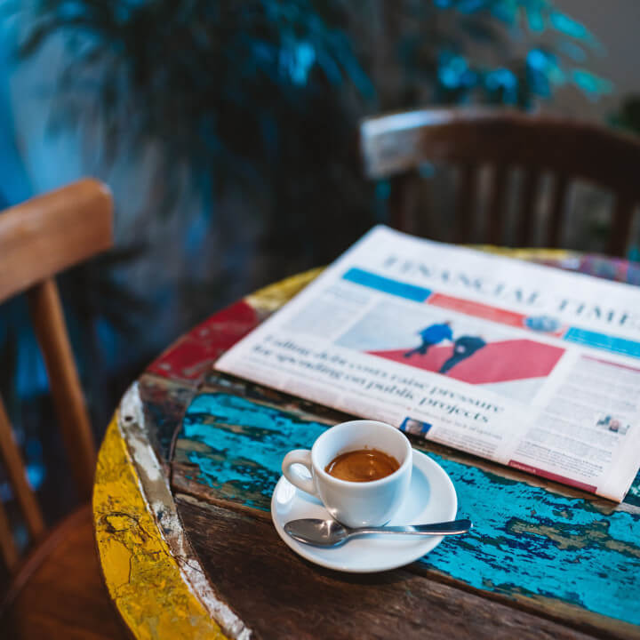 Café a cote d'un journal sur une table